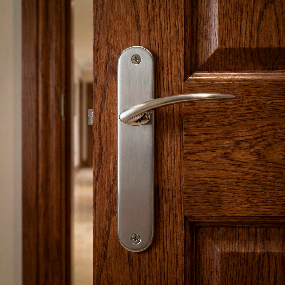 Manilla modelo '440' con placa ovalada de zamak en acabado níquel satinado para puertas