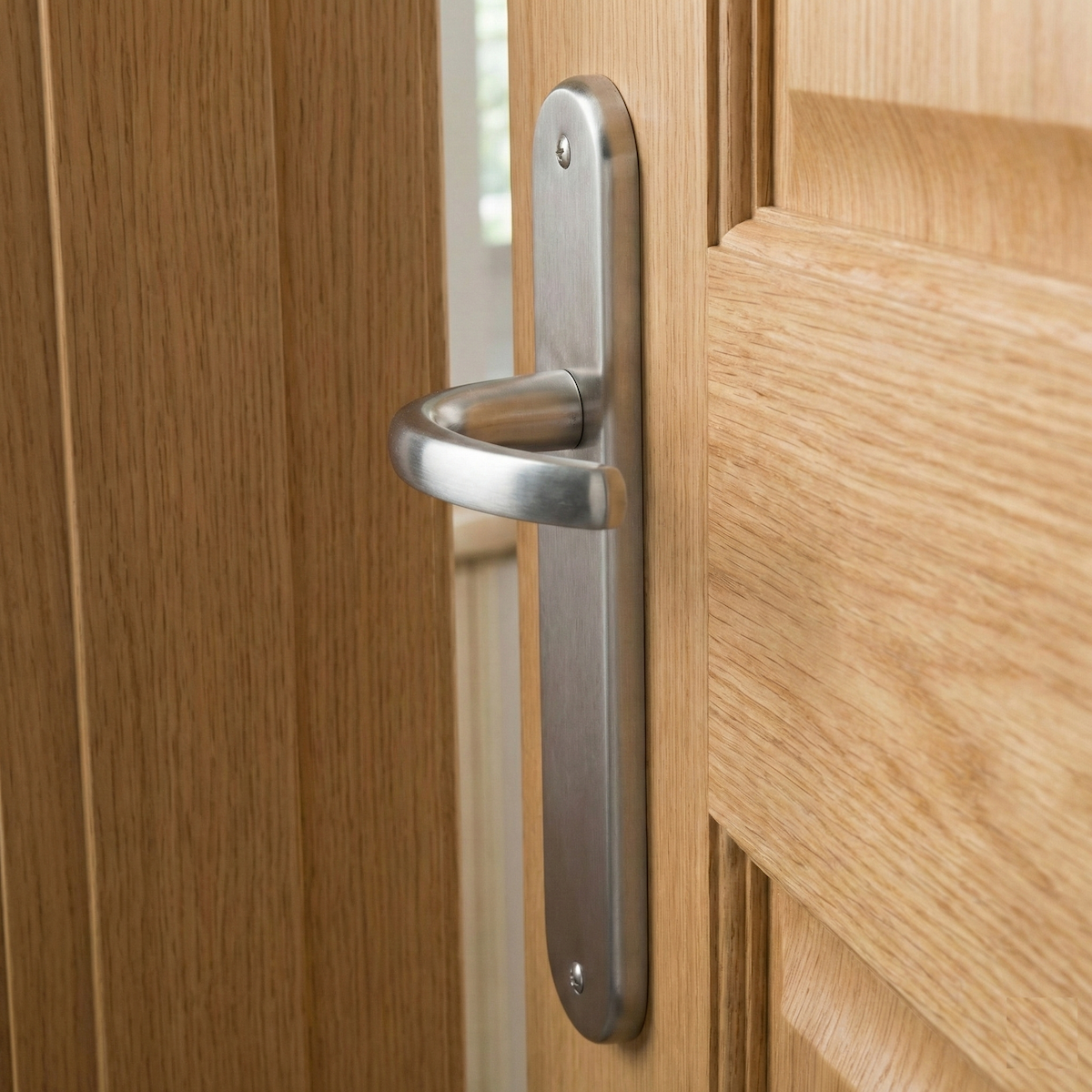 Manilla modelo '110' de zamak con placa oval en acabado níquel satinado para puertas