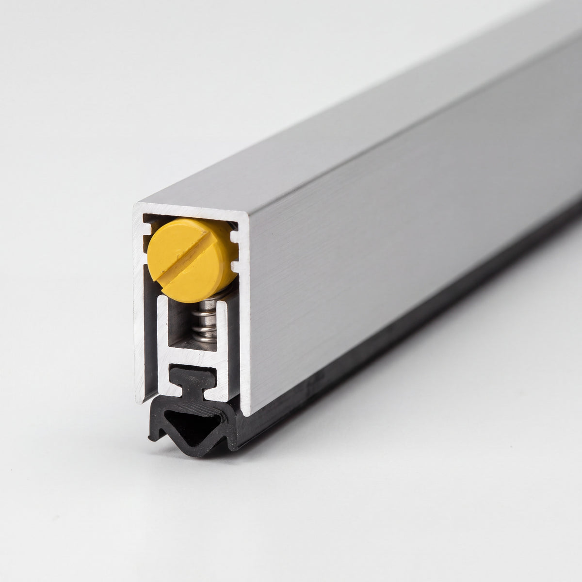 Burlete automático de embutir en aluminio con junta de goma negra y tornillo de ajuste amarillo.