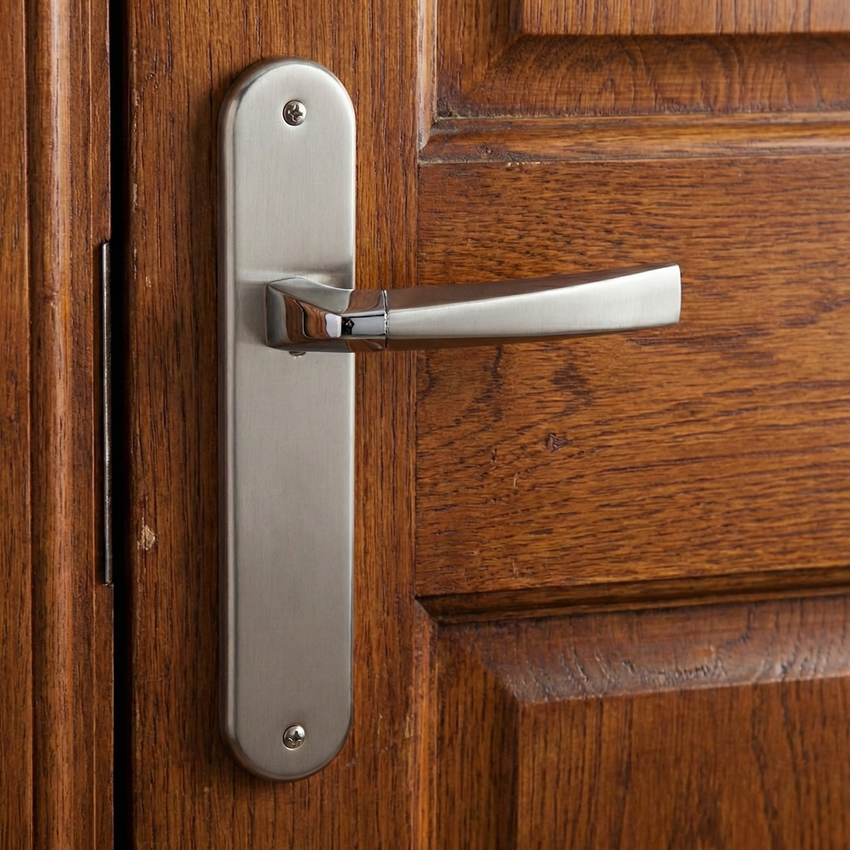 Manilla modelo '320' de zamak con placa ovalada en acabado bicolor para puertas