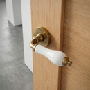 Manilla rústica con roseta redonda de porcelana blanca en acabado cuero