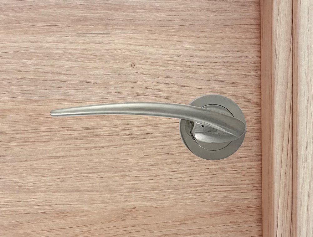 Manilla de zamak con roseta redonda en acabado níquel satinado para puertas de madera
